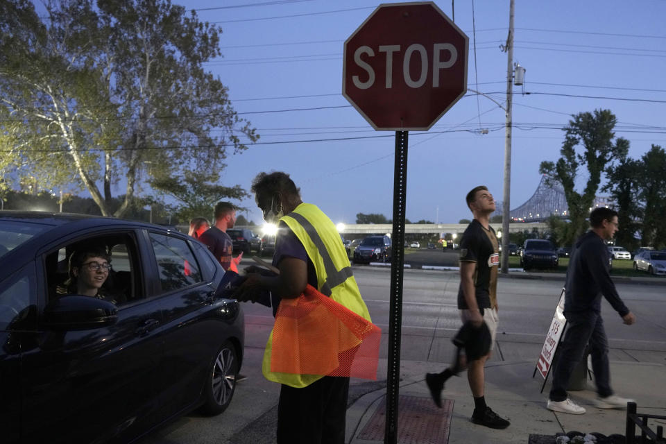 Karen Hull collects a parking fee at the entrance to the Calvary Baptist Church parking lot which is located near the Philadelphia Union's Subaru Park, Wednesday, Oct. 4, 2023, in Chester, Pa. (AP Photo/Michael Perez)