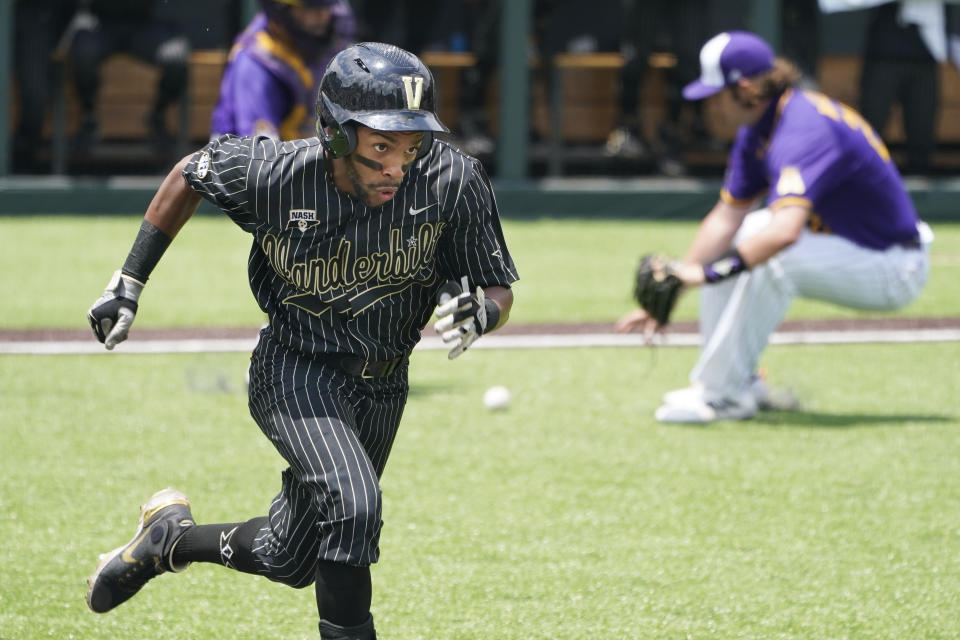 Vanderbilt's Javier Vaz, left, runs to first base to beat out a bunt single as East Carolina pitcher Gavin Williams, right, fields the ball in the seventh inning of an NCAA college baseball super regional game Friday, June 11, 2021, in Nashville, Tenn. Vanderbilt won 2-0. (AP Photo/Mark Humphrey)