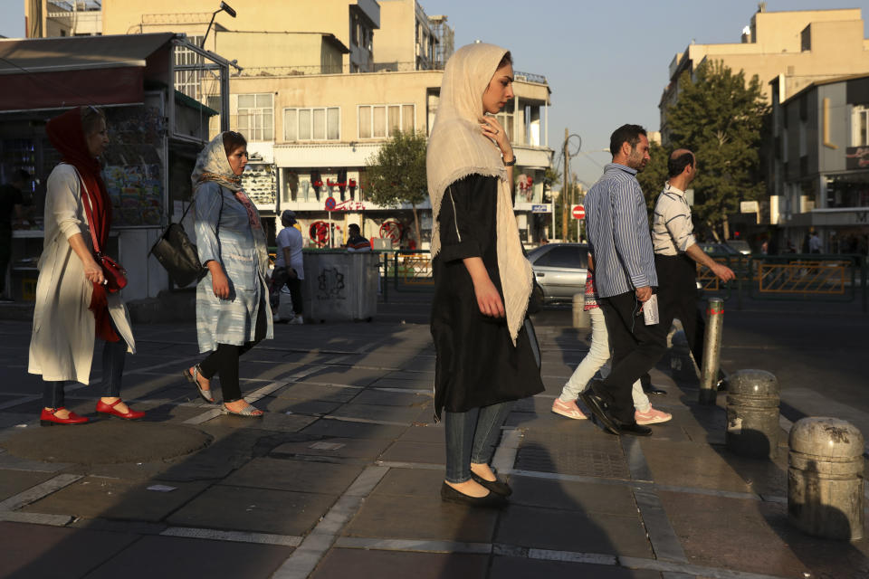 Pedestrians walk on a sidewalk in eastern Tehran, Iran, Monday, Aug. 19, 2019. (AP Photo/Vahid Salemi)