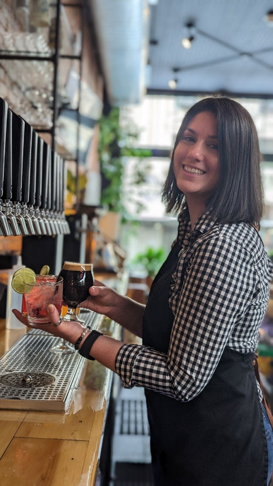 Bagg's Square Brewing Company employee Kayla Cataldo poses with drinks in a promotional shot for National Bartender Day.