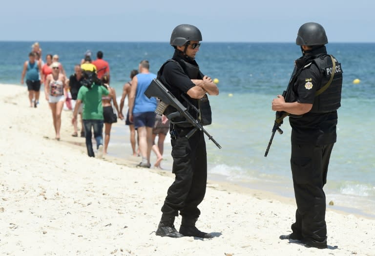 Tunisian police patrol the beach as tourists take part in a ceremony on July 3, 2015, in memory of those killed by a jihadist gunman in front of the Riu Imperial Marhaba Hotel in Port el Kantaoui