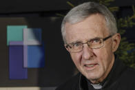 Father Jim Connell poses for a portrait outside his home in Milwaukee on Wednesday, Dec. 2, 2020. Connell, a retired administrator in the Milwaukee Archdiocese who is also a canon lawyer, said AP’s findings convinced him that Catholic entities did not need government aid -- especially when thousands of small businesses were permanently closing amid state-ordered health lockdowns. “Was it want or need?” Connell asked. “Need must be present, not simply the want. Justice and love of neighbor must include the common good.” (AP Photo/Morry Gash)