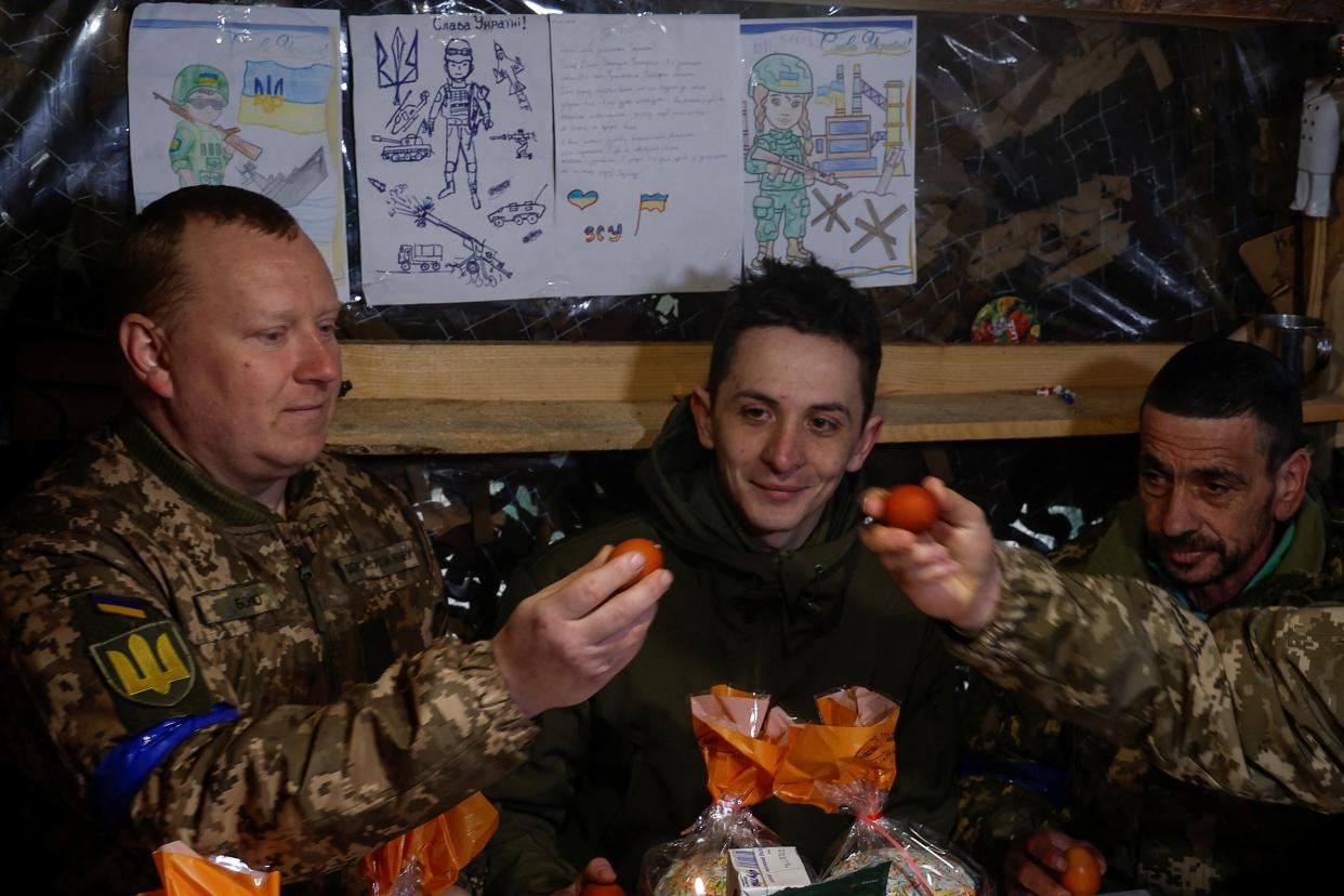 Ukrainian service members tap Easter eggs as they celebrate the Orthodox Easter at a position in direction of the border with Belarus (REUTERS)
