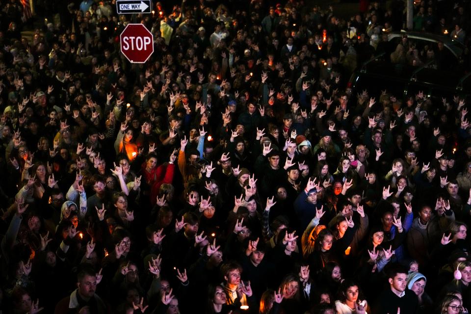 People sign "I love you" at a vigil for the victims of Wednesday's mass shootings, Sunday, Oct. 29, 2023, outside the Basilica of Saints Peter and Paul in Lewiston, Maine.