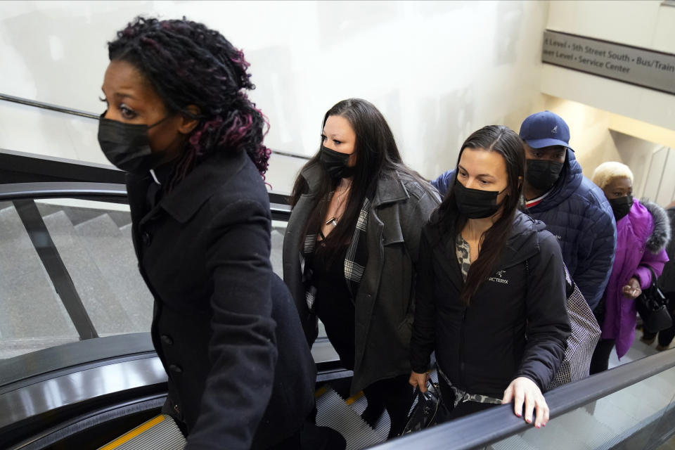 A unidentified member of the clergy, left, leads the family of Daunte Wright, including his mother Katie, second from left, as they arrive Wednesday, Dec. 1, 2021 at the Hennepin County Government Center in Minneapolis for the second day of jury selection for former suburban Minneapolis police officer Kim Potter, who says she meant to grab her Taser instead of her handgun when she shot and killed motorist Daunte Wright. (AP Photo/Jim Mone)