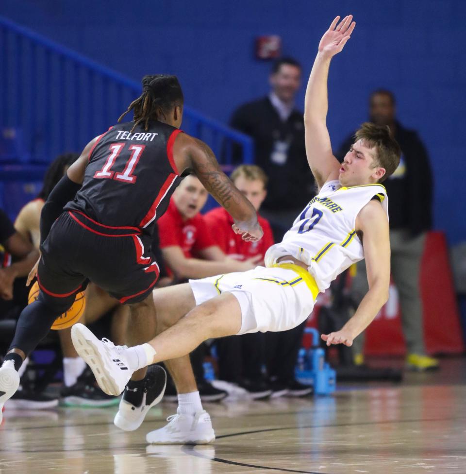 Delaware's Johnny McCoy draws an offensive foul against Northeastern's Jahmyl Telfort in the second half of Delaware's 81-78 win at the Bob Carpenter Center, Saturday, Jan. 28, 2023.