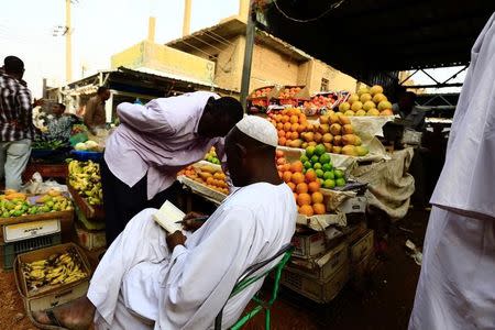 FILE PHOTO: A vendor writes in a notebook at a market in Khartoum July 28, 2016. REUTERS/Mohamed Nureldin Abdallah
