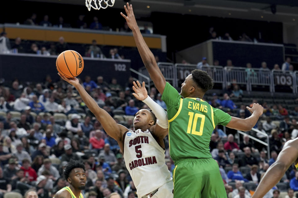 South Carolina's Meechie Johnson (5) shoots around Oregon's Kwame Evans Jr. (10) during the first half of a first-round college basketball game in the NCAA Tournament, Thursday, March 21, 2024, in Pittsburgh. (AP Photo/Matt Freed)