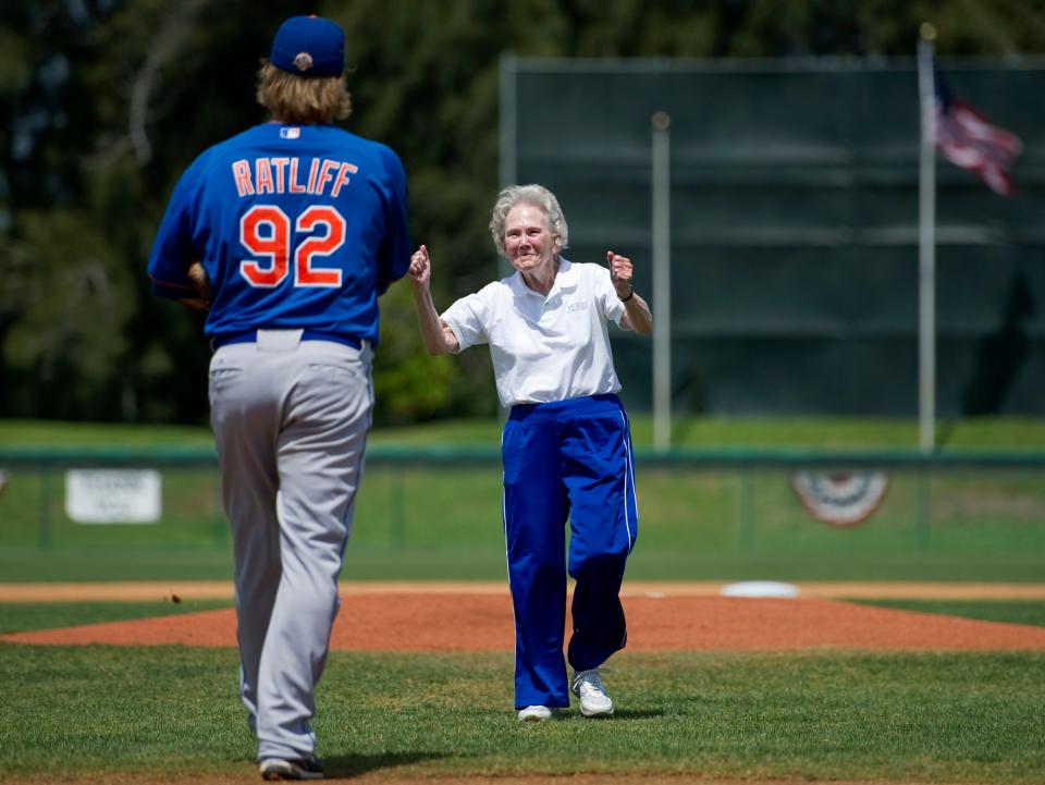 Alma Lee Loy (right), of Vero Beach, pumps her fist after throwing out the first pitch of the Buffalo Bisons' game against the New Orleans Zephyrs at Holman Stadium on Saturday afternoon March 31, 2012. Sean Ratliff (left), of the Buffalo Bisons, caught the pitch.