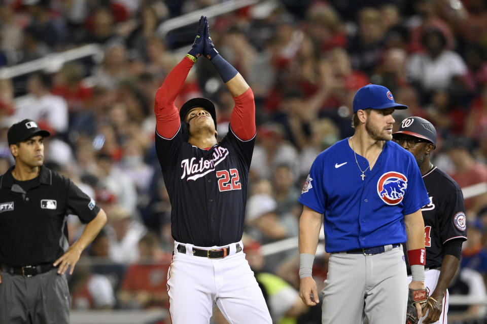 Washington Nationals' Juan Soto (22) gestures as he stands on first with a single next to Chicago Cubs first baseman Patrick Wisdom, right, during the seventh inning of a baseball game Friday, July 30, 2021, in Washington. The Nationals won 4-3.(AP Photo/Nick Wass)