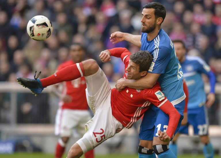 Bayern Munich's striker Thomas Mueller (L) and Hamburg's defender Mergim Mavraj vie for the ballduring the German first division Bundesliga football match between Bayern Munich and Hamburger SV in Munich, southern Germany, on February 25, 2017