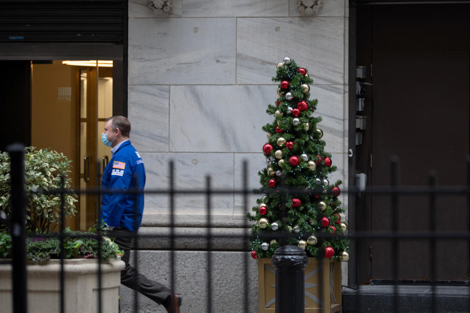 NEW YORK, NEW YORK - DECEMBER 02: A stock broker walks past a Christmas Tree displayed in front of the New York Stock Exchange on December 02, 2020 in New York City. (Photo by Alexi Rosenfeld/Getty Images)