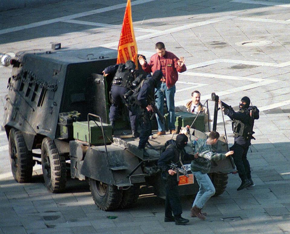 FILE - In this Friday May 9, 1997 file photo, Police special forces with machine guns arrest two of the self-proclaimed Venetian separatists who had occupied the bell tower in St. Mark's square, in the heart of Venice. The vehicle is a mock armored car brought in by the group who occupied the bell tower overnight. Italian special operations units on Wednesday, April 2, 2014, arrested 24 secessionists who were allegedly planning a violent campaign aimed at making the wealthy northeastern Veneto region independent. Police said in a statement that the group had built an armored vehicle that they intended to deploy in St. Mark's Square in Venice — reminiscent of a 7 ½-hour takeover of the piazza's famed bell tower by secessionists in 1997. TV footage showed the so-called tank was a tractor that had been armed in some fashion. Italian media reported that the secessionists intended to deploy the vehicle on the eve of European Parliamentary elections in May, which will be a measure of growing anti-Europe sentiment arising from harsh austerity measures to fight the economic crisis. (AP Photo/Franco Proietti, File)