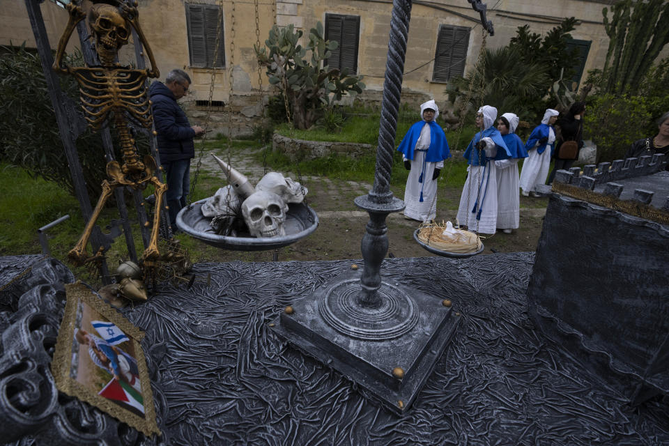 Children look at a "Mistero", a float dedicated to the Apocalypse that features a small Israeli and Palestinian flag before the start of a procession in Procida Island, Italy, Friday, March 29, 2024. Italy is known for the religious processions that take over towns big and small when Catholic feast days are celebrated throughout the year. But even in a country where public displays of popular piety are a centuries-old tradition, Procida's Holy Week commemorations stand out. (AP Photo/Alessandra Tarantino)