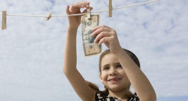 Girl hanging one million dollar bill on clothes-line