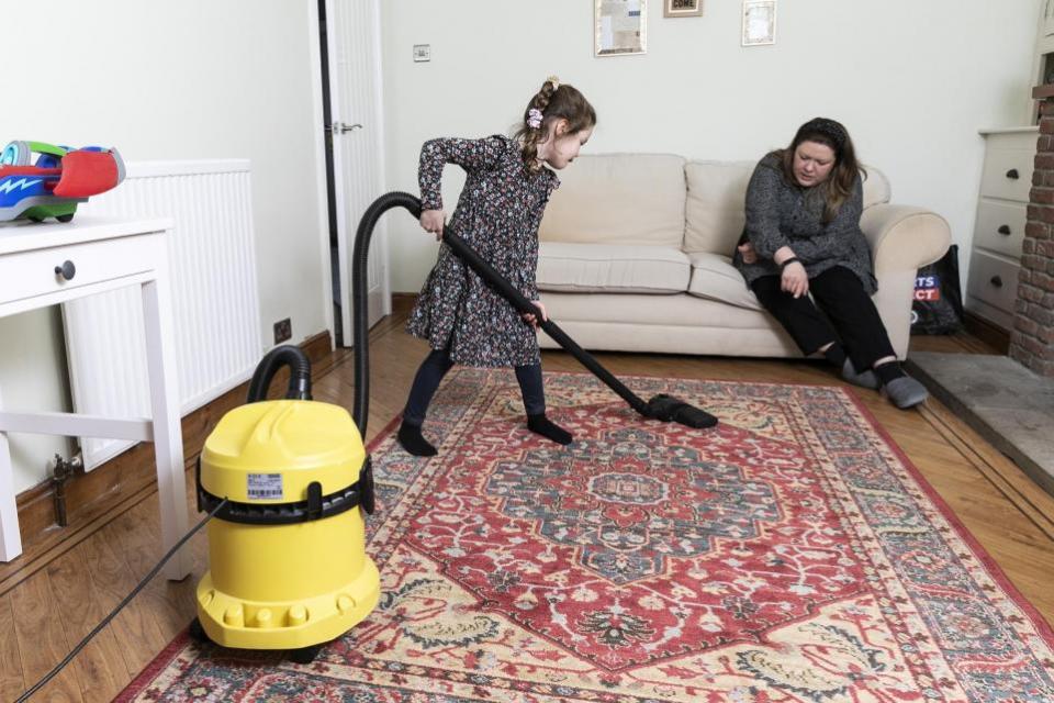 York Press: Elena watches Violet, five, vacuum the front room. Picture: SWNS
