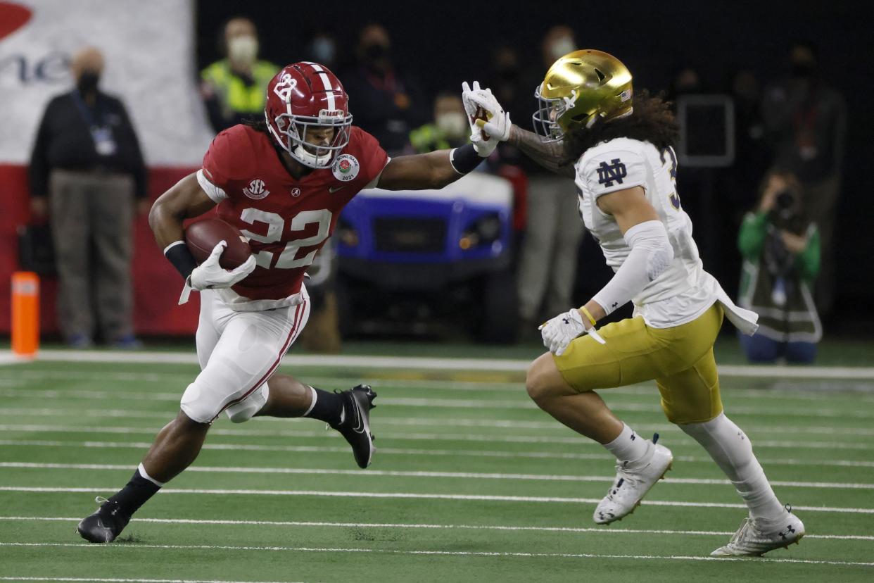 Alabama running back Najee Harris (22) fights off a tackle attempt by Notre Dame linebacker Marist Liufau (35) in the first half of the Rose Bowl NCAA college football game in Arlington, Texas, Friday, Jan. 1, 2021. (AP Photo/Michael Ainsworth)