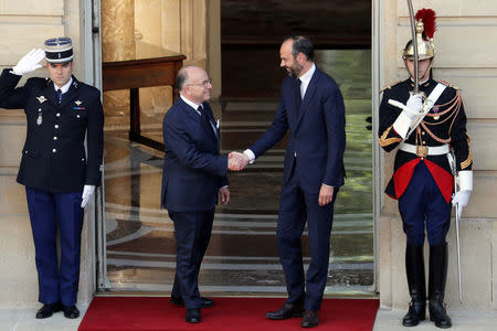 Newly-appointed French Prime Minister Edouard Philippe (R) is greeted by his predecessor Bernard Cazeneuve (L) during a handover ceremony at the Hotel Matignon, in Paris, France, May 15, 2017. REUTERS/Thomas Samson/Pool