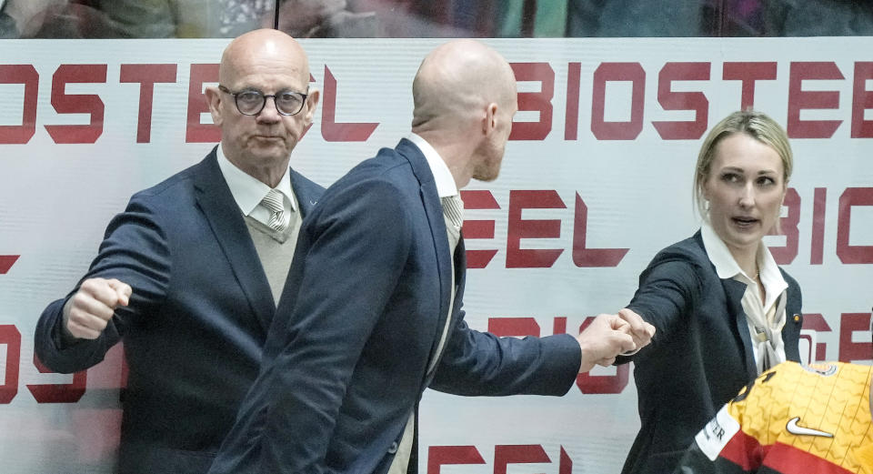 FILE - Germany's assistant coach Jessica Campbell, head coach Toni Soderholm and assistant coach Tom Rowe from right, celebrate after winning the group A Hockey World Championship match between Germany and Italy in Helsinki, Finland, Friday May 20 2022. The Coachella Valley Firebirds have hired Jessica Campbell as the American Hockey League’s first female assistant coach. (AP Photo/Martin Meissner, File)