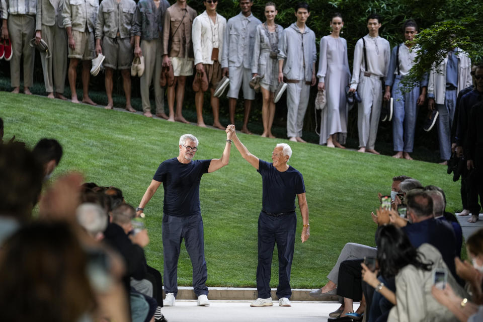 Giorgio Armani, right, and Leo Dell'Orco accept applause at the conclusion of the Giorgio Armani men's Spring Summer 2022 collection, in Milan, Italy, Monday, June 21, 2021. (AP Photo/Luca Bruno)