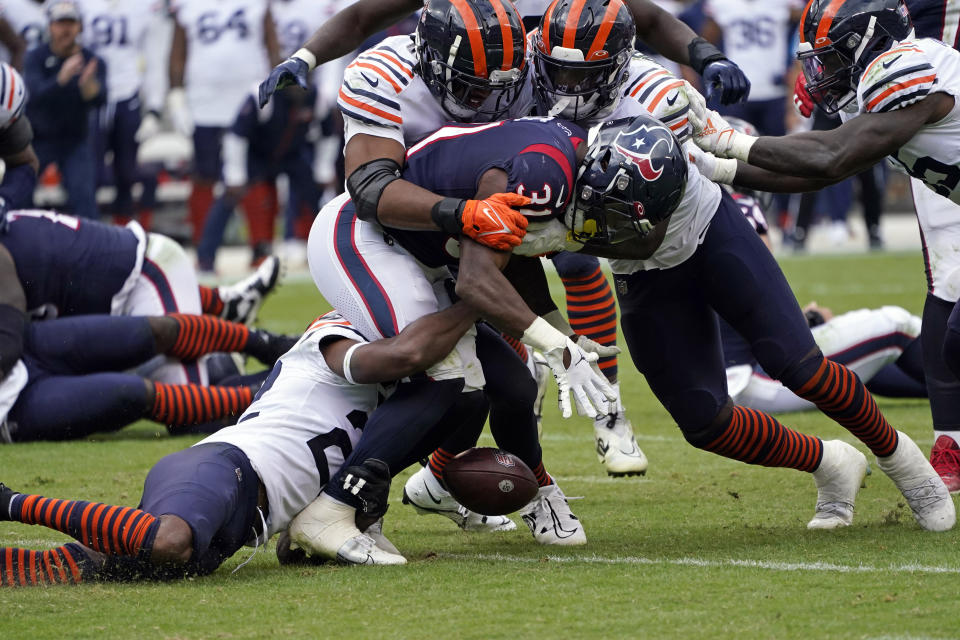 Houston Texans running back Dameon Pierce (31) fumbles the football as he is hit by Chicago Bears defenders during the second half of an NFL football game Sunday, Sept. 25, 2022, in Chicago. The Texans recovered the fumble. (AP Photo/Charles Rex Arbogast)
