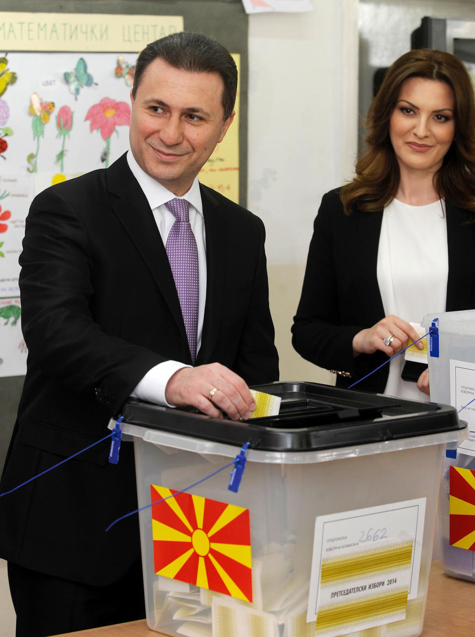 Macedonian Prime Minister and leader of the ruling conservative VMRO-DPMNE party Nikola Gruevski, left, accompanied by his wife Borkica Gruevska, right, casts his ballot in Skopje, Macedonia, on Sunday, April 27, 2014. Polls opened for Macedonia's double election, a presidential election runoff and snap national elections. Conservatives are favored to win both contests. (AP Photo/Boris Grdanoski)