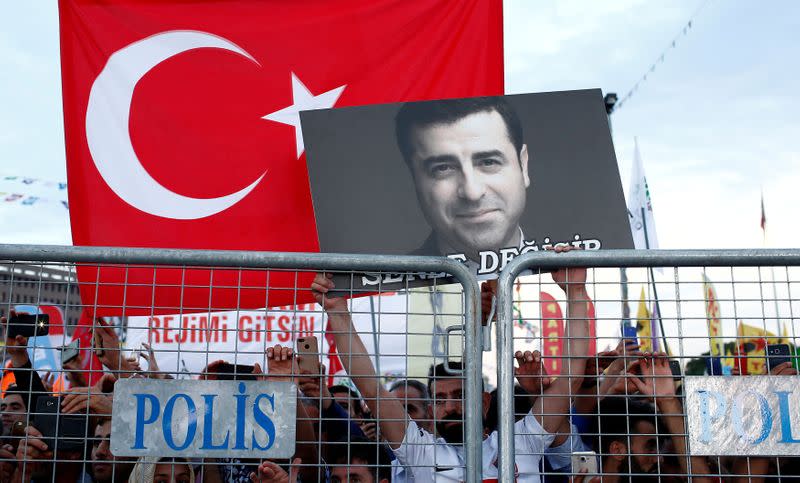 FILE PHOTO: A supporter of Turkey's main pro-Kurdish Peoples' Democratic Party holds a portrait of their jailed former leader and presidential candidate Selahattin Demirtas during a campaign event in Istanbul
