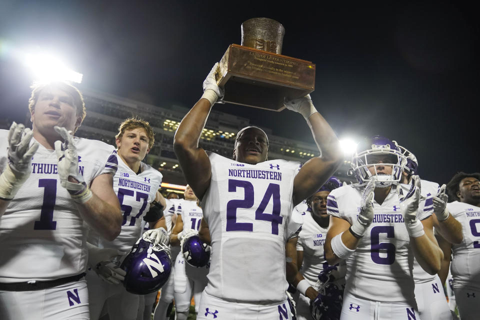 Northwestern defensive back Rod Heard II (24) holds up the Land of Lincoln Trophy after his team defeated Illinois in an NCAA college football game Saturday, Nov. 25, 2023, in Champaign, Ill. (AP Photo/Erin Hooley)