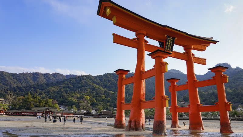 A photo of people approaching the Grand Torii Gate of the world cultural heritage Itsukushima Shinto shrine during low tide in Miyajima, Hiroshima, western Japan, on Thursday, Dec. 22, 2022. 