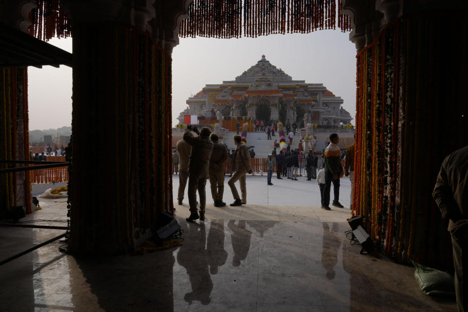 Policemen stand guard as the workers decorate a temple dedicated to Hindu deity Lord Ram on the eve of its grand opening, in Ayodhya, India, Sunday, Jan. 21, 2024. (AP Photo/Rajesh Kumar Singh)