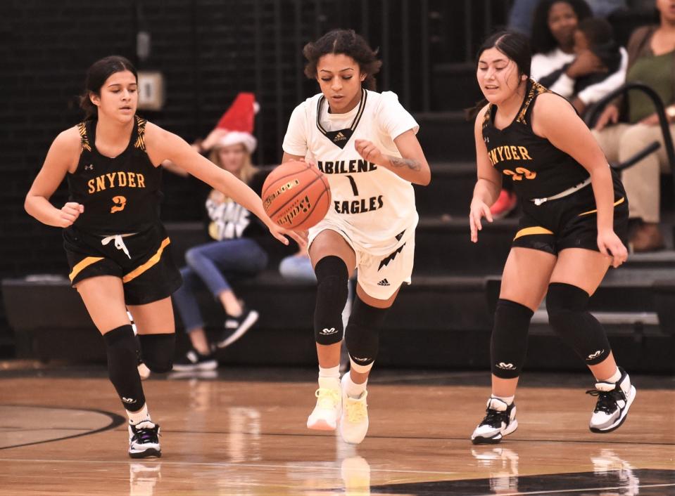 Abilene High's Kayley Washington, center, brings the ball up court as Snyder's Jayci Medrano, left, and Avery Murray defend in the second half.