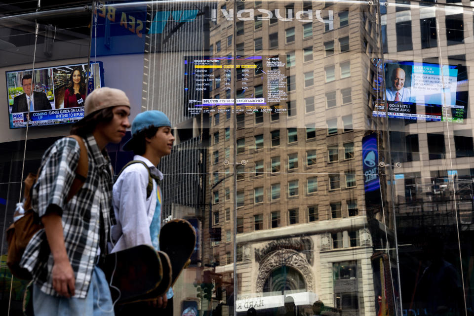 People walk past the Nasdaq MarketSite, Wednesday, July 13, 2022, in New York. Surging prices for gas, food and rent catapulted U.S. inflation to a new four-decade peak in June. (AP Photo/Julia Nikhinson)