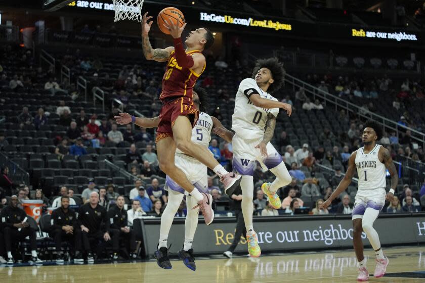 USC's Kobe Johnson shoots around Washington's Koren Johnson during the Pac-12 tournament Wednesday in Las Vegas.