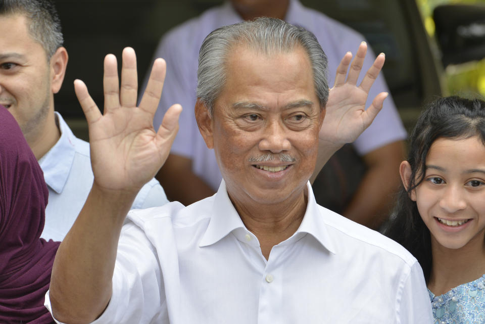 Politician Muhyiddin Yassin, center, waves to media after outside his house after he being appointed as the new prime minister in Kuala Lumpur, Malaysia, Saturday, Feb. 29, 2020. Malaysia's king has appointed seasoned politician Muhyiddin Yassin as the new prime minister, trumping Mahathir Mohamad's bid to return to power after a week of political turmoil that followed his resignation as prime minister. (AP Photo/John Shen Lee)