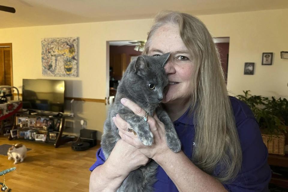 Juanita Mengel holds her cat Lola-Pearl in her home in Amanda, Ohio on Monday, Dec. 11, 2023.