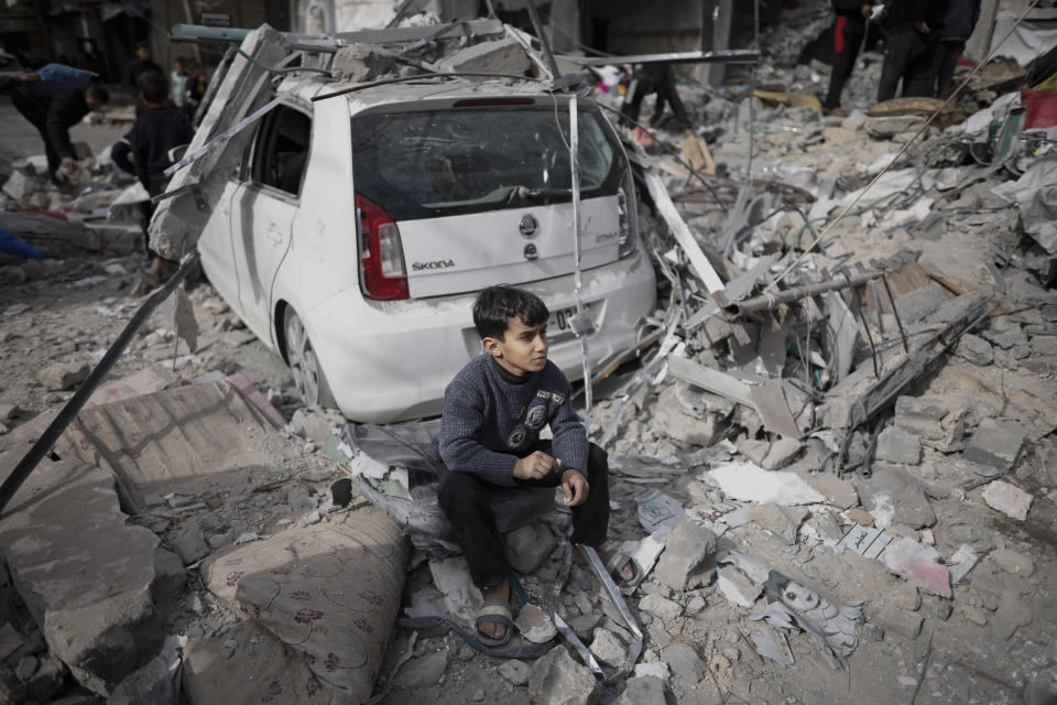 A Palestinian boy sits outside his home destroyed in an Israeli strike in Kahan Younis, Gaza Strip, Friday, Jan. 12, 2024. AP Photo/Mohammed Dahman)