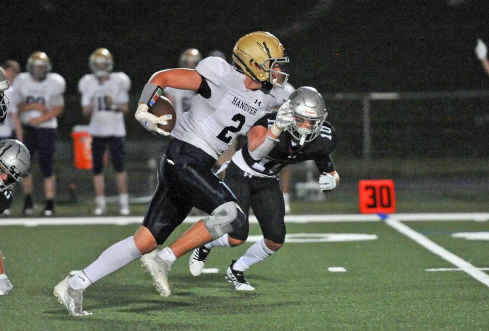 Hanover's David Quinlan races down field as Duxbury's Brendan Bonner, right, closes in during the high school football season opener at Duxbury High School, Thursday, Sept. 8, 2022.