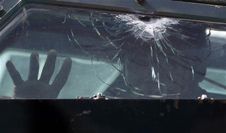 A government soldier inside an armoured vehicle peers out of a bulletproof window, which was damaged during a firefight with Muslim rebels from Moro National Liberation Front (MNLF), in a residential district in Zamboanga city in southern Philippines September 12, 2013. REUTERS/Erik De Castro