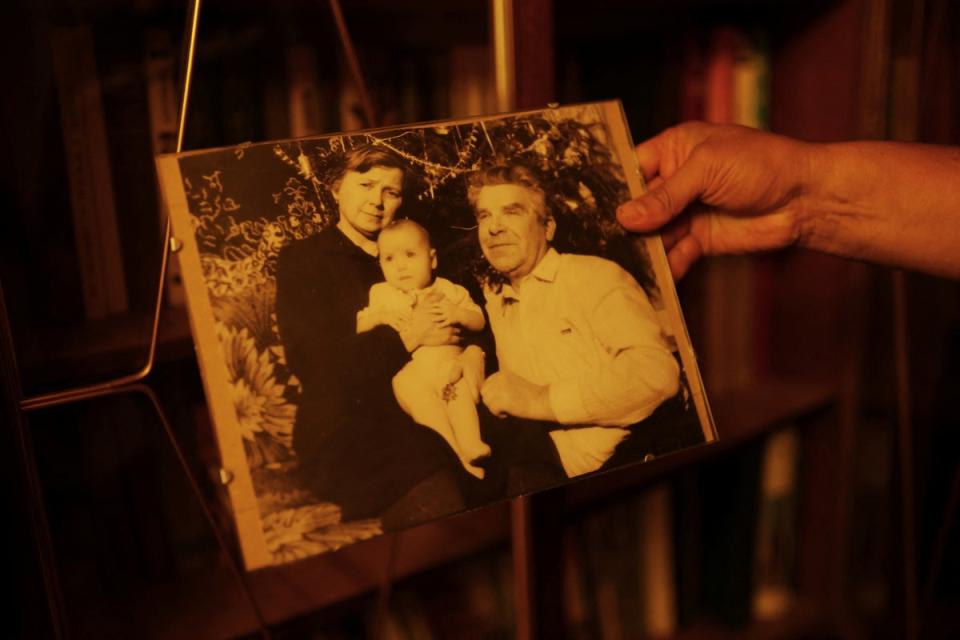 Fedor holds a photo of his wife Natalya as a baby with her parents Maria, and her late father, Vasilii (Reuters)