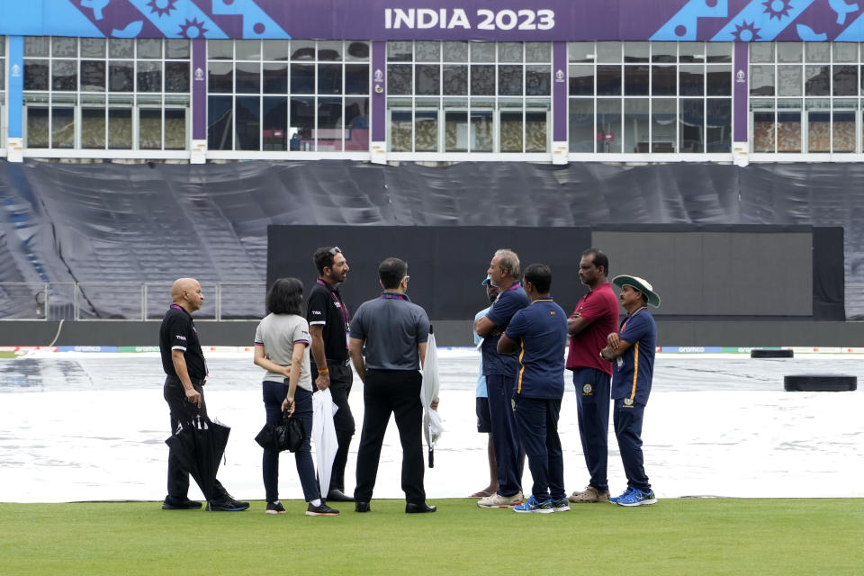 Officials and umpires talk after inspecting the ground as heavy rains delays the start of ICC Men's Cricket World Cup warm up match between Afghanistan and South Africa in Thiruvananthapuram, India, Friday, Sept. 29, 2023. (AP Photo/Manish Swarup)