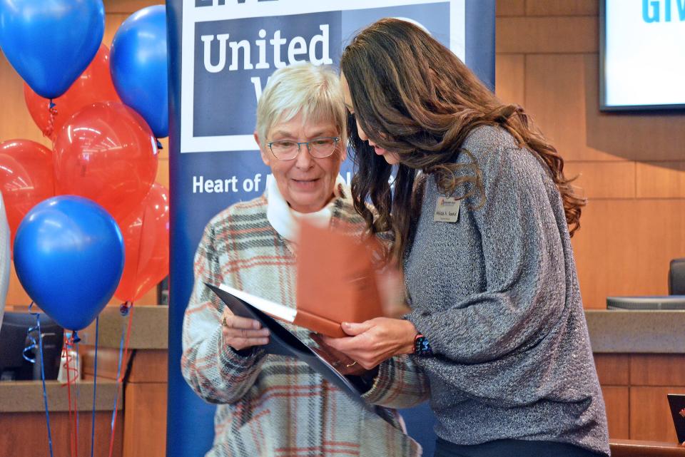 United Way Give 5 volunteer training graduate Kathy Jones receives a gift Thursday from Rainbow House Executive Director Melissa Faurot during a ceremony held at Columbia City Hall. Jones will volunteer at Rainbow House, along with her husband, Bob.