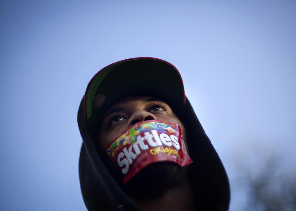 <p>Jajuan Kelley, of Atlanta, wears a Skittles wrapper over his mouth during a rally in memory of Trayvon Martin, the unarmed 17-year-old who was killed by a Florida neighborhood watch captain while returning from a convenience store with a bag of Skittles and an iced tea, in Atlanta, March 26, 2012. (AP Photo/David Goldman, File) </p>