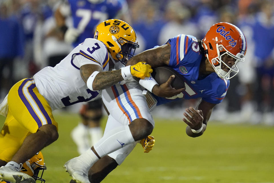 Florida quarterback Anthony Richardson, right, dives for extra yardage as he is tackled by LSU safety Greg Brooks Jr. (3) during the first half of an NCAA college football game, Saturday, Oct. 15, 2022, in Gainesville, Fla. (AP Photo/John Raoux)