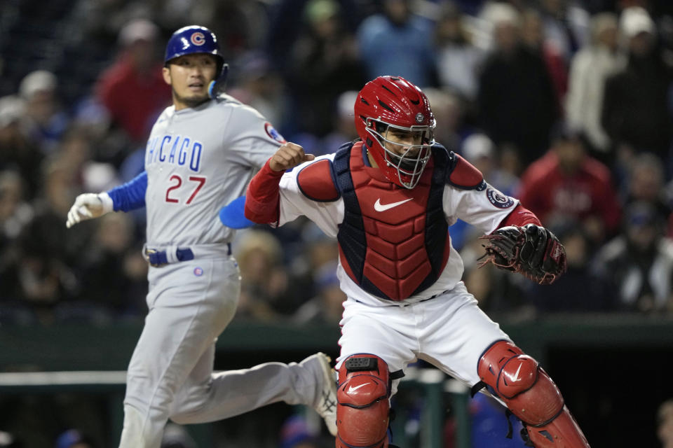 Washington Nationals catcher Keibert Ruiz, right, gestures as he and Chicago Cubs' Seiya Suzuki (27) watch Chicago Cubs Patrick Wisdom and Nelson Velazquez out on double play ending the baseball game with the Nationals winning, in Washington, Wednesday, May 3, 2023. (AP Photo/Manuel Balce Ceneta)