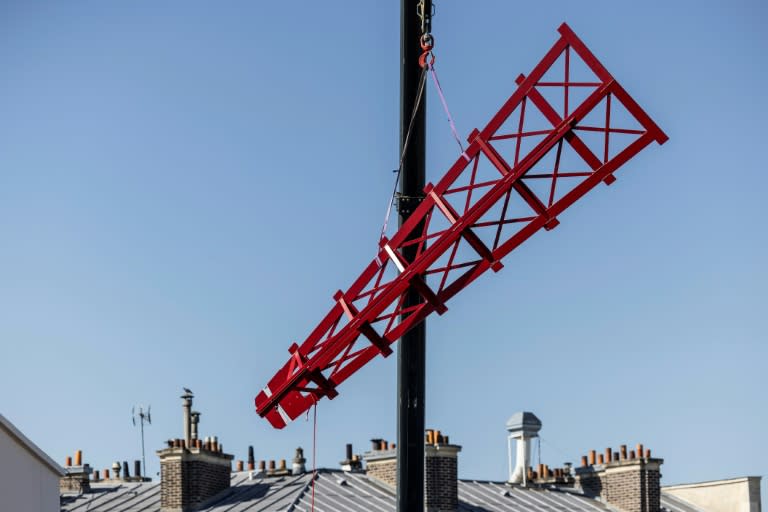 Une grue soulève l'une des quatre pales provisoires pour l'instllaer au sommet du cabaret le Moulin Rouge, le 24 juin 2024 à Paris (OLYMPIA DE MAISMONT)