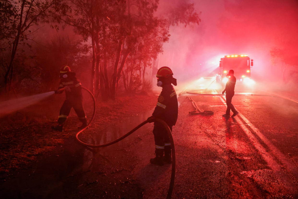 Firefighters try to extinguish a wildfire in Dionysos, Greece, on Monday. 