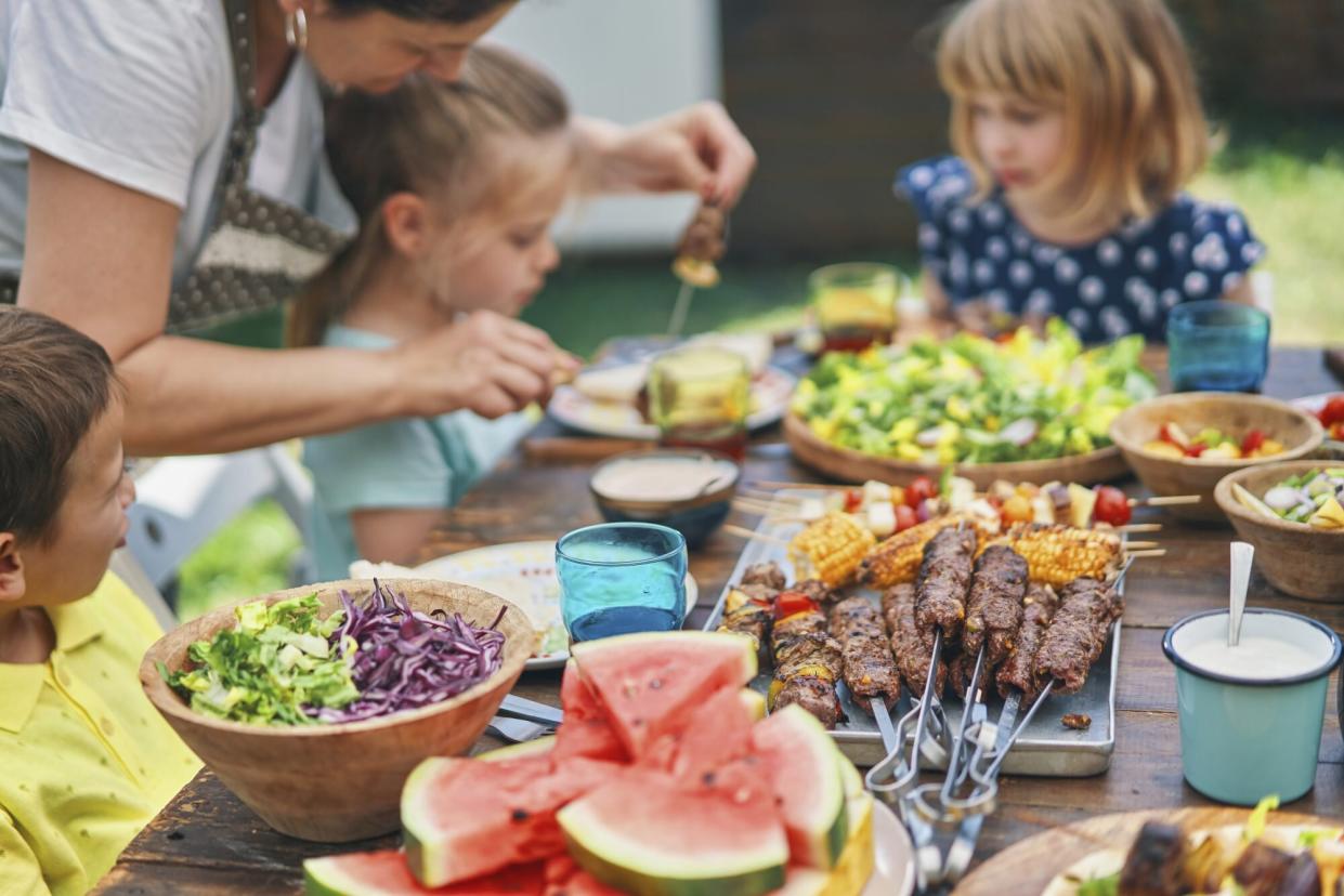 family enjoying barbecue outside