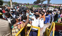 NEW DELHI, INDIA - MARCH 28: A traffric police personnel holds a child as a wave of migrants workers try to Kaushambi Roadways Bus Stand on Day 4 of the 21 day nationwide lockdown -- to check the spread of coronavirus, at Delhi UP border (opposite Anand Vihar Bus Stand, on March 28, 2020 in New Delhi, India. (Photo by Ajay Aggarwal/Hindustan Times via Getty Images)