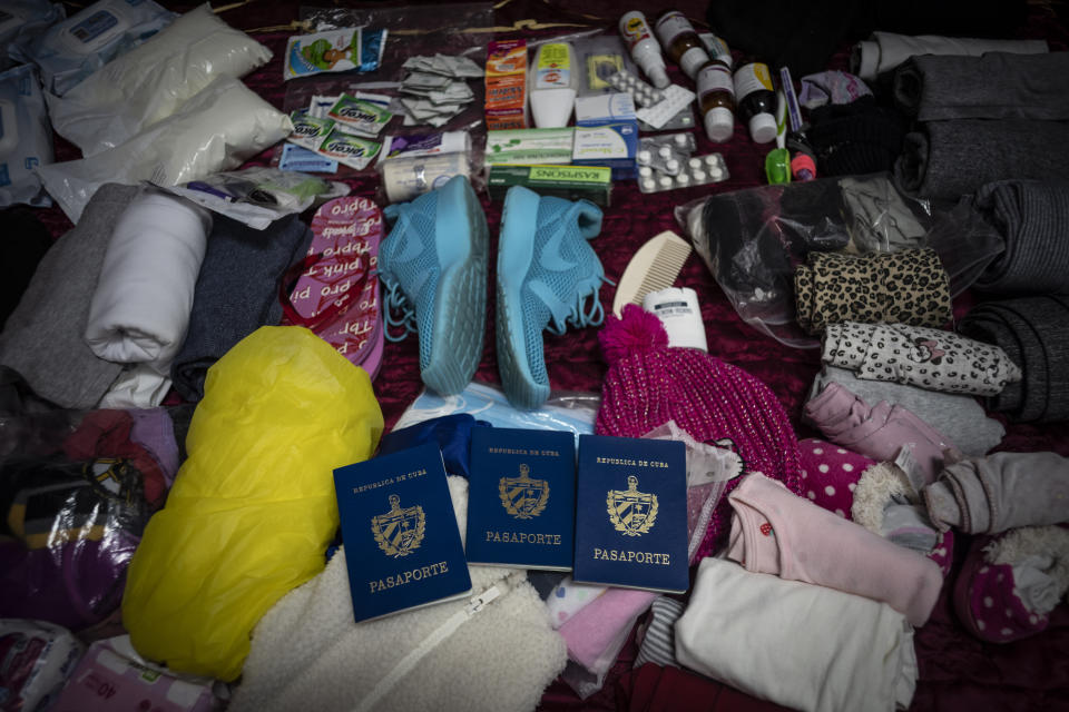 The passports of sisters Melanie and Merlyn Rolo Gonzalez, and Melanie's 1-year-old daughter, Madisson, lie amid supplies for their journey to the U.S., at their home in Havana, Cuba, Saturday, Dec. 10, 2022. It's a voyage that hundreds of thousands of Cubans have made over the last two years in a historic wave of migration. (AP Photo/Ramon Espinosa)