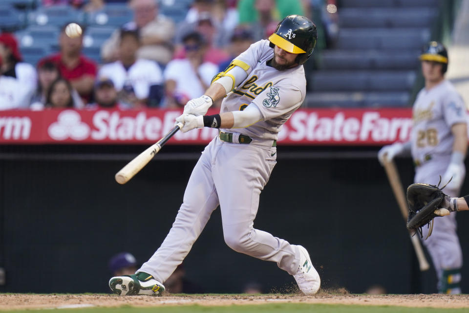 Oakland Athletics' Jed Lowrie hits a sacrifice fly to bring in Matt Olson to score during the 10th inning of a baseball game against the Los Angeles Angels, Sunday, Sept. 19, 2021, in Anaheim, Calif. (AP Photo/Jae C. Hong)